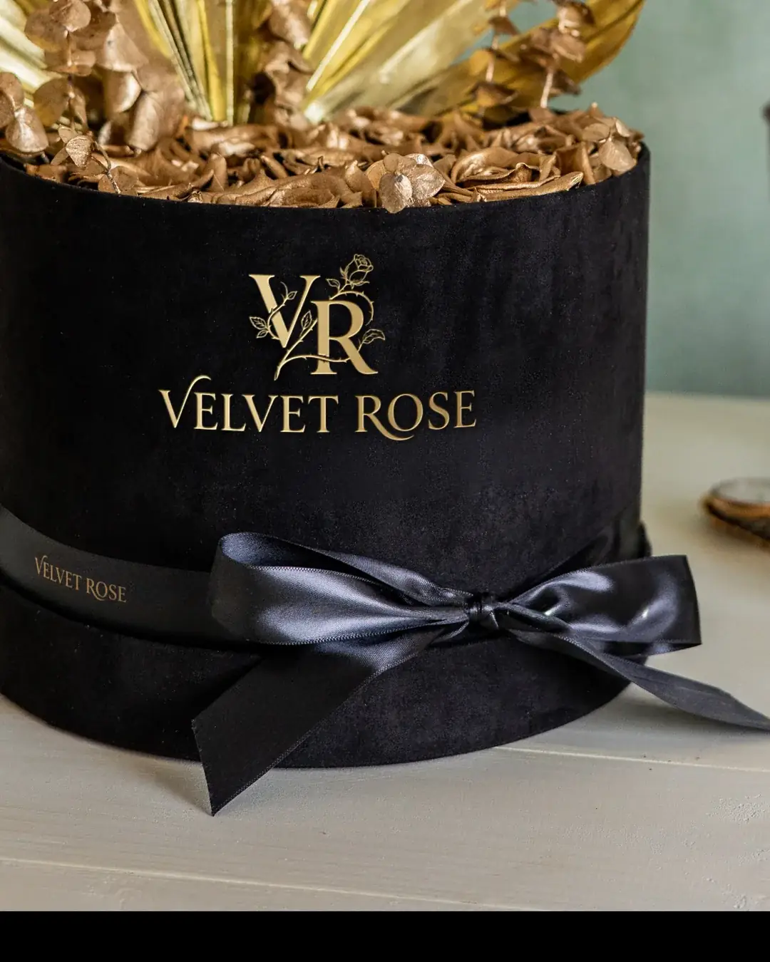 Noir & Gold hat box tied with a black satin ribbon