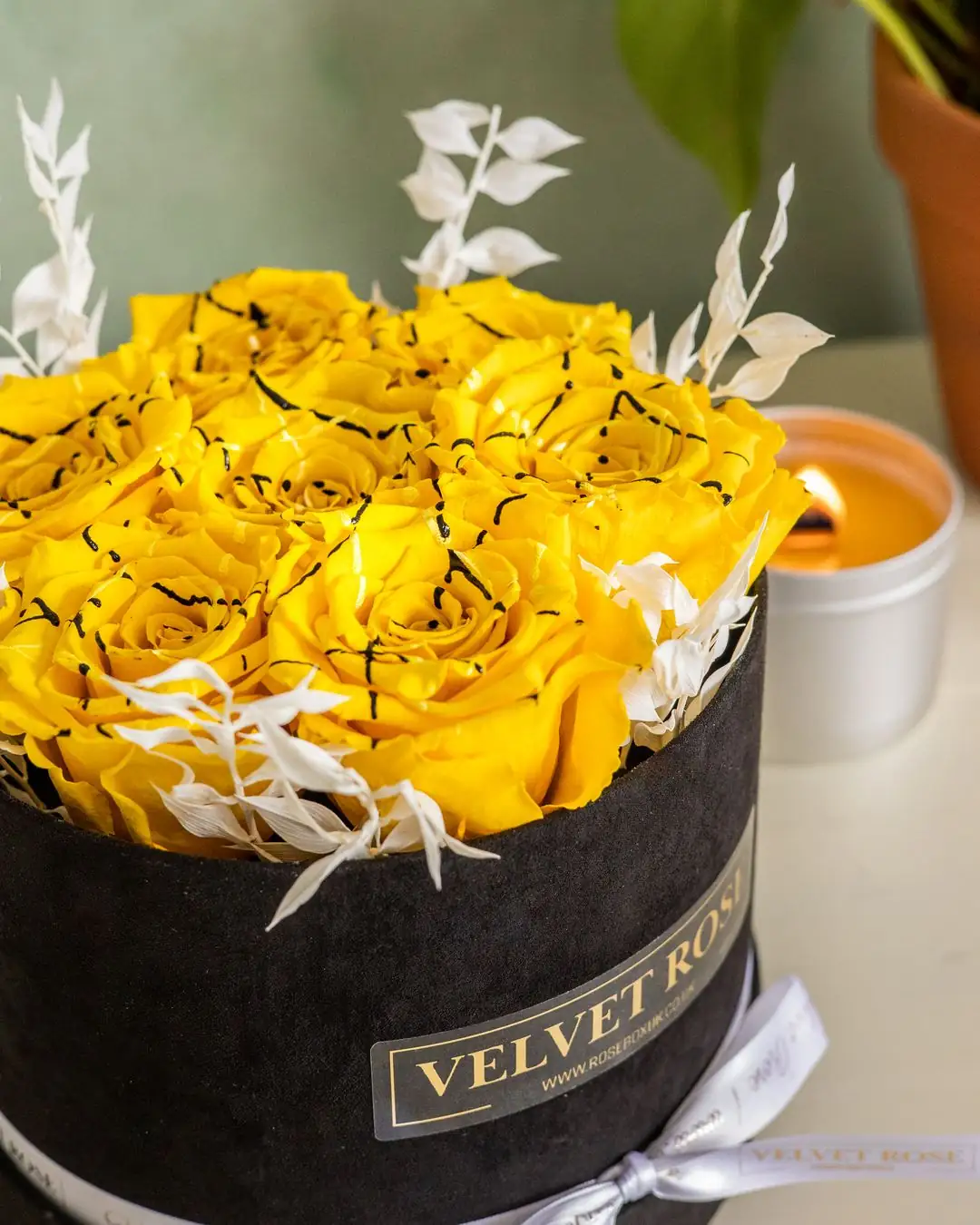 Noir Soleil: yellow roses in black velvet, in a round velvet hat box