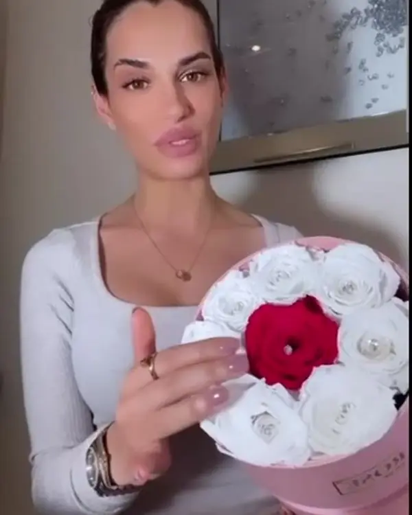 Nicole Bass holding a pink Velvet Rose box of white roses